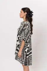 Camisa oversize de manga corta, con diseño estampado geométrico en blanco y negro, escote en V con cuello mao y cierre frontal con botones.