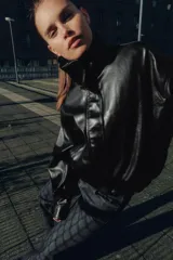 Chaqueta de efecto piel con cuello subido, manga larga con puños y bajo elástico. Presenta cierre frontal con cremallera y botones a presión ocultos, además de bolsillos laterales y forro interior.