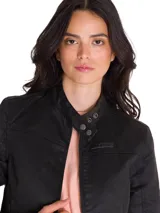 Chaqueta estilo moto para mujer, confeccionada en tela encerada color negro. Presenta cuello mao con cierre de broche, cierre frontal con cremallera y bolsillos laterales con cierre.