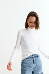 Remera básica de manga larga con cuello polera, confeccionada en tejido suave y elástico.