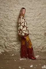 Sweater de lana tejido a mano con diseño geométrico en tonos marrón y beige, de calce holgado, cuello redondo y puños ajustados.