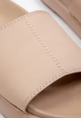 Sandalia baja blanca de símil cuero con cinta ancha sobre la capellada y plataforma de 2 cm de alto.