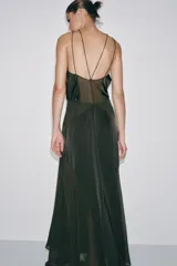 Vestido largo de cuello halter con tirantes finos y hombros descubiertos. Presenta un diseño con costuras marcadas, forro interior a tono y cierre lateral con cremallera oculta.