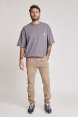 Pantalón de jean color beige, corte slim fit, con bolsillos delanteros y traseros.