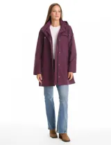 Gabardina impermeable de corte evasé en color azul. Presenta cierre frontal oculto con botones a presión, cuello alto, capucha fija y bolsillos laterales con cierre. Incluye forro interno.