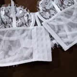 Conjunto de lencería de dos piezas en encaje blanco, compuesto por un corpiño tipo bustier con aro y tirantes regulables, y una bombacha cavada con detalles de tul y encaje floral.