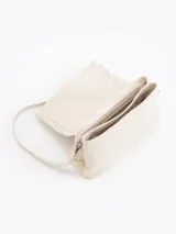 Cartera de hombro negra confeccionada en cuero vacuno, con diseño de solapa frontal decorada con volados de cuero y cierre metálico tipo candado.