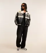 Campera masculina de cuero sintético, modelo boxy, con cuello inglés, manga larga, estampa lettering, detalles contrastantes, bolsillos y cierre por cremallera.