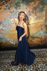 Vestido largo strapless de encaje negro con transparencias y espalda descubierta con tiras cruzadas, de corte entallado y falda de caída suelta.