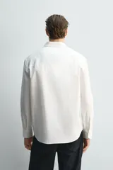 Camisa de corte relajado confeccionada en una mezcla de algodón, lyocell y seda de origen italiano. Presenta cuello abotonado, manga larga con puños abotonados y cierre frontal con botones.