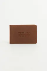 Tarjetero marrón de cuero con costuras en los bordes y logo de la marca grabado en el frente.