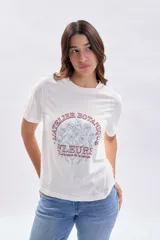 Remera de manga corta color crudo con cuello redondo y estampa frontal con motivos botánicos y texto en tonos rojizos y azules.