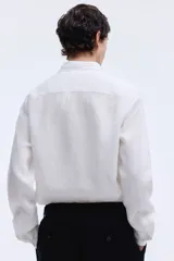 Camisa H&M de lino liviano color blanco, de corte entallado slim fit, con cuello italiano y manga larga.