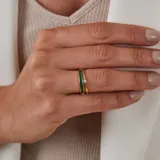 Anillo de oro amarillo 18k con diseño de media alianza engastada con esmeraldas en talla brillante.