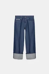 Jeans de tiro bajo color azul oscuro, corte recto, con cinco bolsillos y cierre frontal de cremallera y botón. Presenta un efecto lavado y el bajo está acabado en vuelta.