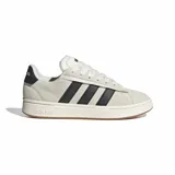 Championes Adidas Grand Court Alpha de estilo urbano, confeccionados en cuero sintético color beige con las icónicas tres tiras laterales en negro. Presentan un diseño de corte bajo con mediasuela Cloudfoam para mayor amortiguación y suela de caucho color caramelo.
