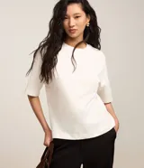 Blusa básica de algodón color blanco, con cuello redondo, mangas cortas y corte oversized.