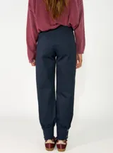 Pantalon de gabardina en color azul oscuro, de corte holgado con botamangas ajustadas mediante elástico.