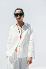 Camisa color coral confeccionada en lino 100%, de corte recto, con cuello solapa, manga larga con puños abotonados y cierre frontal con botones.