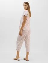 Conjunto pijama de remera de manga corta y pantalón capri blanco con delicado estampado floral en tonos rosados y verdes, confeccionado en tejido acanalado fino con escote redondo y detalle de gota con botón.