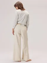 Pantalon de corte ancho y tiro alto, confeccionado en una mezcla de fibras naturales. Presenta un diseño de pierna recta y holgada, con bolsillos traseros aplicados y costuras reforzadas a lo largo de la pierna.