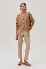 Cárdigan color camel de tejido de punto con trenzas en las mangas y cierre frontal con botones.