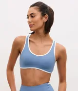 Top deportivo Get Over confeccionado en microfibra azul con bies blanco en contraste, diseño tipo nadador y copas desmontables.