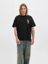 Remera negra de algodón con cuello redondo y mangas cortas. Estampado en la espalda con diseño de serpiente enroscada en rosas y texto 'On Tour 1990 Originals Co.'.