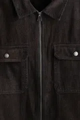 Sobrecamisa de pana de algodón con cuello clásico, cierre frontal de cremallera, mangas largas con puños abotonados y bolsillos superiores con solapa y botón.
