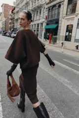 Jersey de punto de corte holgado con cuello solapa asimétrico y mangas anchas por debajo del codo.