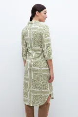 Vestido camisero midi color pistacho con estampado abstracto en blanco, de corte recto y manga 3/4.