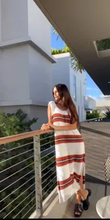 Vestido tejido de algodón color crudo, con rayas horizontales rojas y escote redondo.