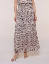 Vestido maxi de gasa beige con estampado de lunares marrones, escote halter sin mangas, cintura elastizada con lazo de ajuste y falda larga estructurada en paneles escalonados con forro interno.