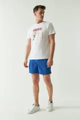 Short de baño liso de color azul, con cintura elástica ajustable mediante cordón, dos bolsillos laterales y uno trasero. Confeccionado en tejido ligero de secado rápido.