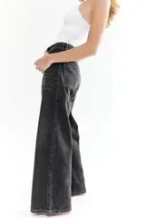 Pantalón de jean negro con costuras blancas y corte amplio.