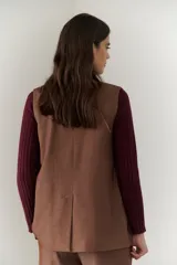 Chaleco azul con cuello en V y cierre frontal con botones marrones.