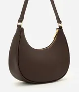 Cartera baguette de cuero sintético marrón, con cierre de cremallera, asa ajustable y detalles metálicos en tono dorado claro.