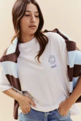 Remera blanca de manga corta con estampado lineal en color azul que incluye ilustraciones de elementos típicos como un mate, un termo, un pájaro, el sol y olas.