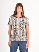 Remera de manga corta con estampado animal print de serpiente en tonos neutros y cuello redondo en color negro.