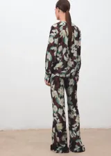 Pantalón largo estilo flare de tiro medio, con cintura elástica y forro interior, con estampado floral en tonos oscuros y verdosos.