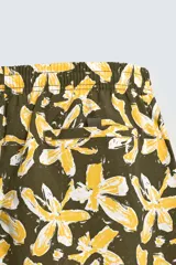 Bañador de hombre con estampado floral en tonos amarillo y blanco sobre fondo verde oliva. Presenta cintura elástica ajustable con cordón, bolsillos frontales y forro interior.