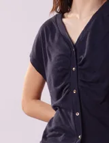 Remera de lino color negro, marca Zac & Rachel. Escote en V con abertura y botones. Delantera con frunce.