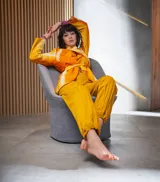 Chaqueta de lana merino afieltrada color naranja con teñido artesanal tie-dye, cuello alto que se prolonga como cinturón y bolsillos laterales.