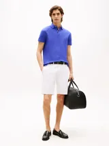 Chomba azul de Tommy Hilfiger, de corte regular, con cuello tipo chomba, cartera de dos botones, mangas cortas y logo bordado en el pecho.