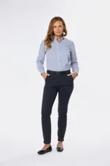 Pantalón largo de gabardina elastizada color azul marino, corte skinny, con bolsillos delanteros y traseros, y presillas para cinturón.