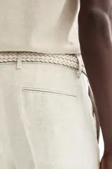 Pantalón de traje de corte ajustado confeccionado en lino liviano. Presenta cierre con corchete oculto, raya marcada en las piernas, bolsillos laterales y bolsillos traseros ribeteados.