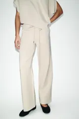 Pantalón de tiro medio confeccionado en tejido de punto elástico con pierna recta. Cuenta con cintura elástica ajustable mediante cordones y bolsillos laterales.