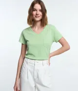 Remera básica de algodón color verde menta, con cuello en V, mangas cortas y un pequeño bolsillo frontal en el pecho.