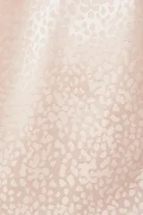 Top lencero color rosa pálido, con escote en V y volados en el borde del escote. Presenta un sutil estampado jacquard de animal print.