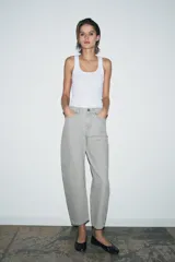 Jeans de tiro medio con corte tapered, confeccionados en denim de color negro con costuras en contraste. Presentan diseño de cinco bolsillos, trabillas en la cintura y cierre frontal con cremallera y botón.